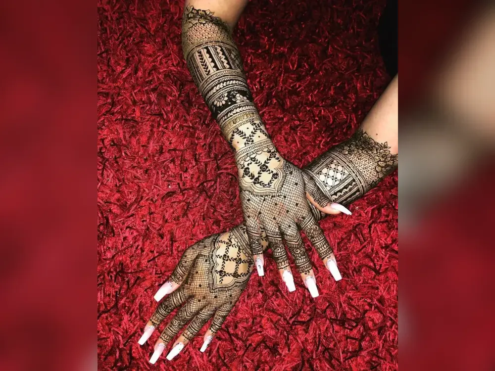 A hand and forearm of bridal mehndi styled against red fabric for photography