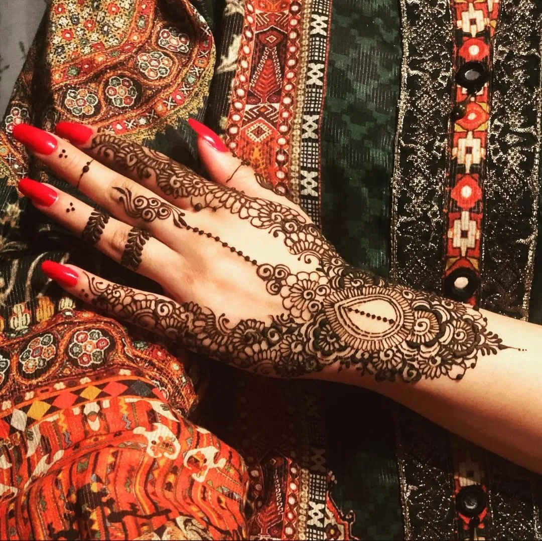 A bride's hand with detailed bridal henna styled for wedding photography