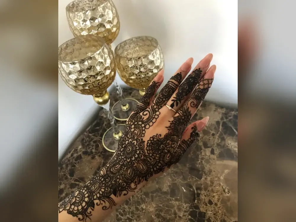 Delicate Eid-style henna design on the back of a hand