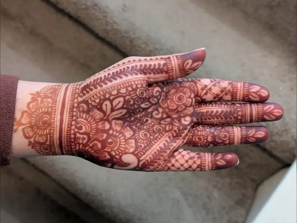 A dense floral palm design in the reddish-brown that natural henna produces