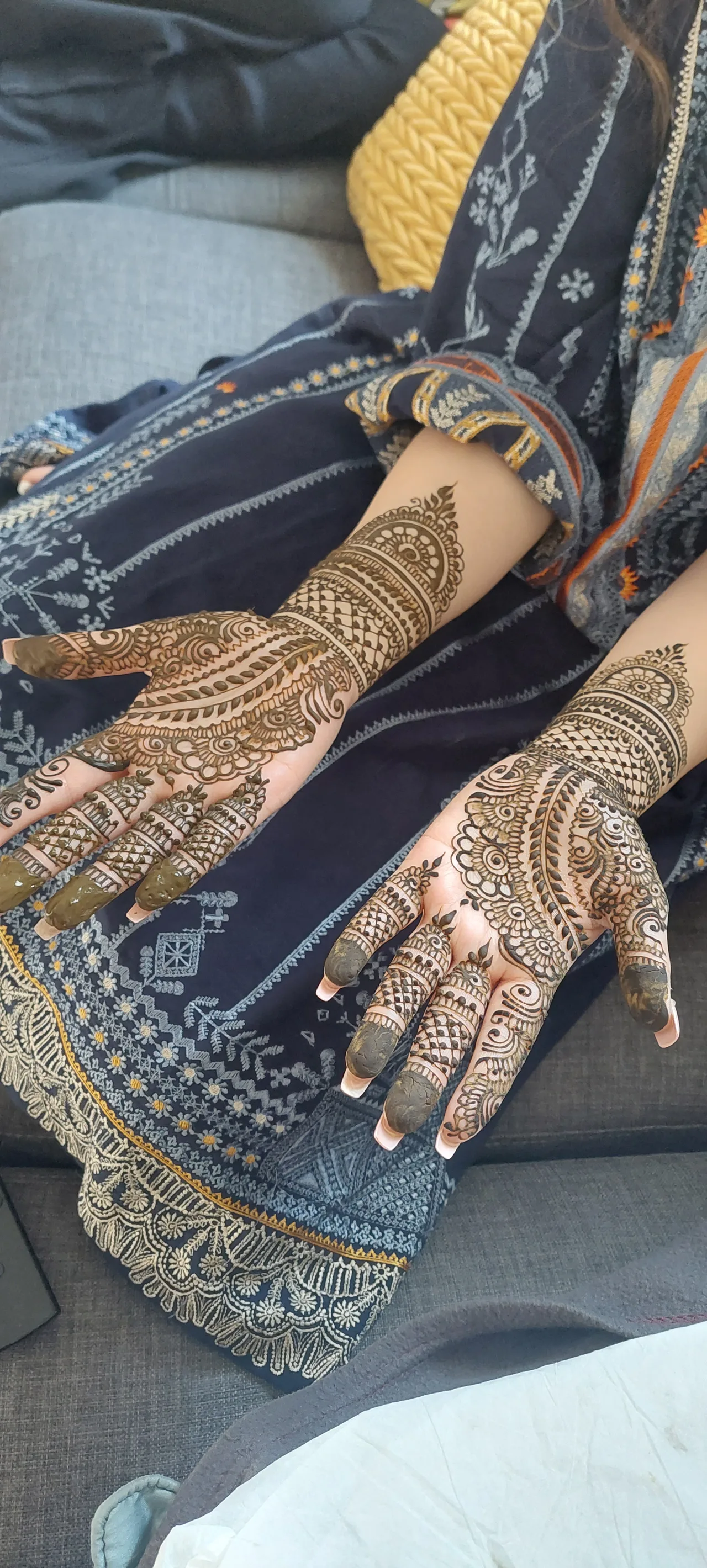 A reddish-brown henna design on a hand