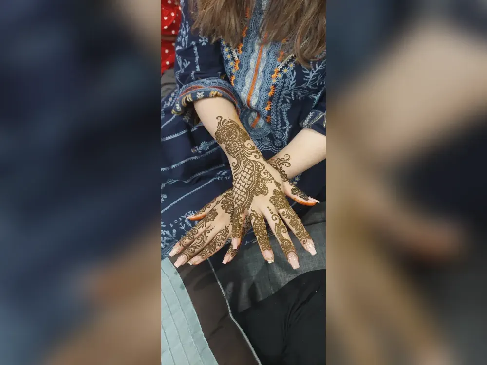 Deep reddish-brown henna stain on the back of a hand at peak color, two days after application