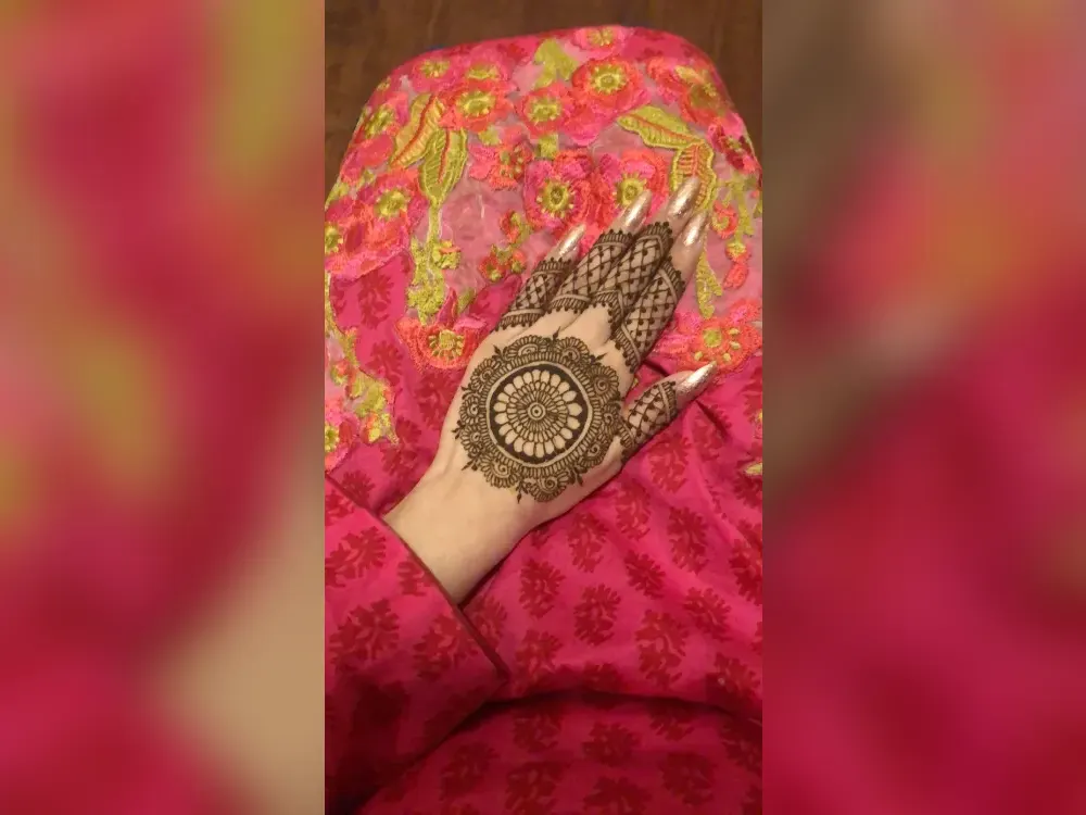 Deep, dark reddish-brown henna stain at peak colour on a hand