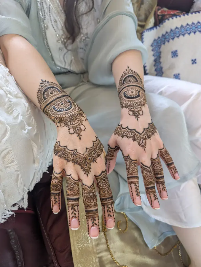 Karwa Chauth mehndi design on both hands with a wrist medallion and open space around it
