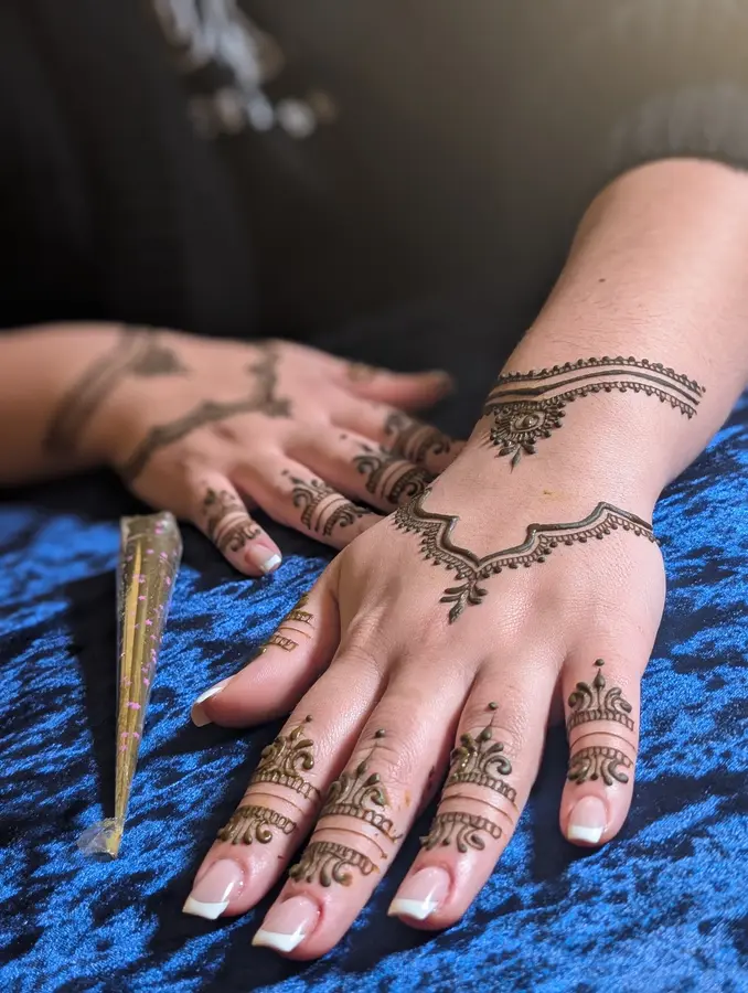 Karwa Chauth mehndi design on the back of one hand, a light bracelet band at the wrist