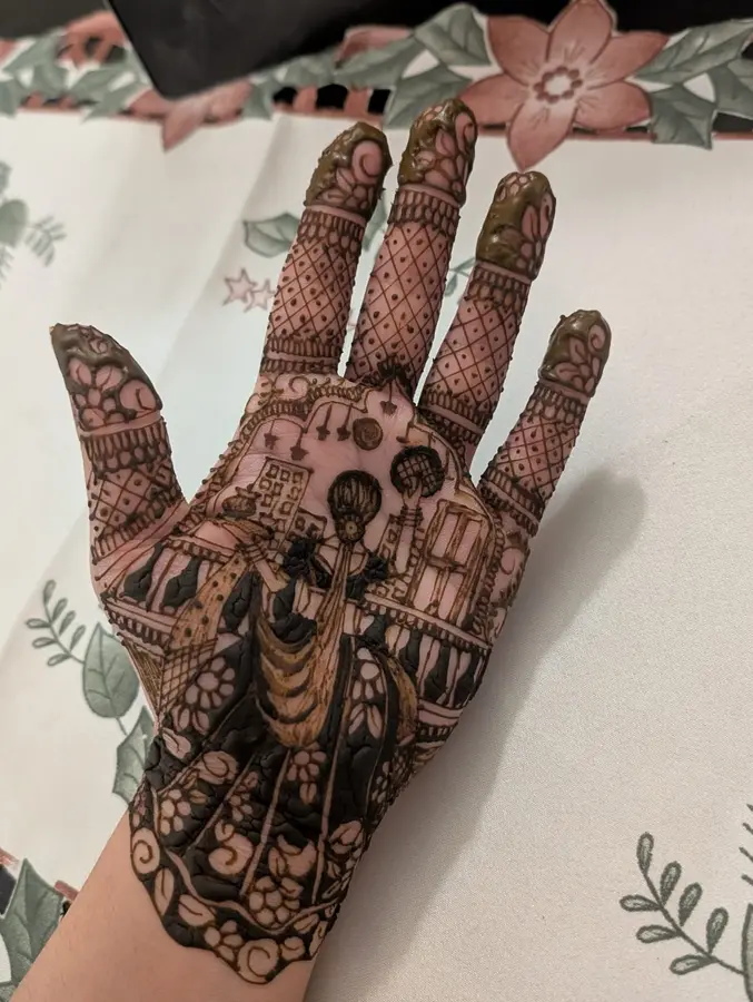 Karwa Chauth mehndi design filling the palm with domes, a figure and a moon motif