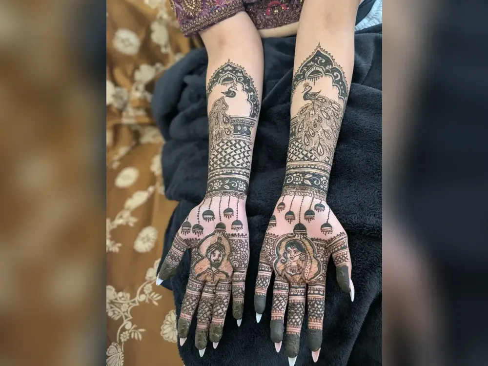 Bridal mehndi with peacock and figurative motifs covering both hands and forearms