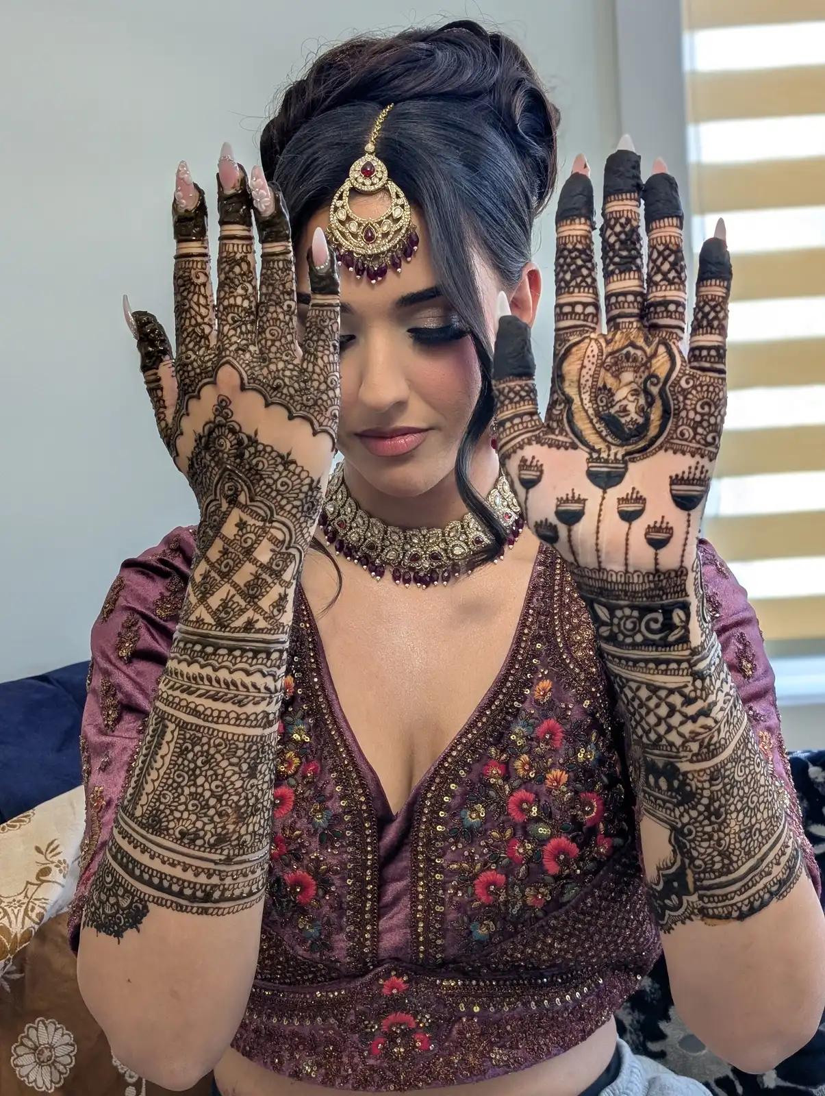A Calgary bride holding up both hands, her mehndi covering the palms and forearms