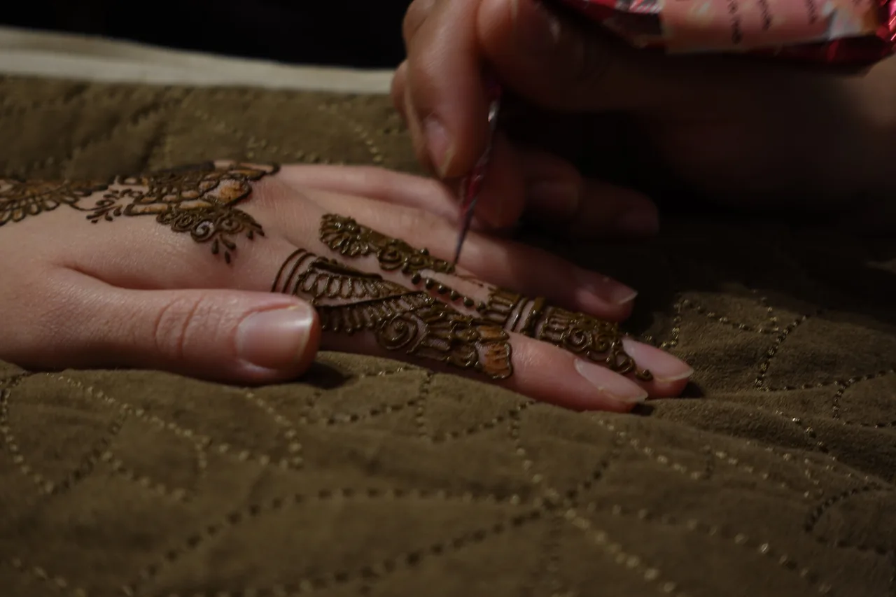 A natural henna design on hands, made with fresh-mixed paste