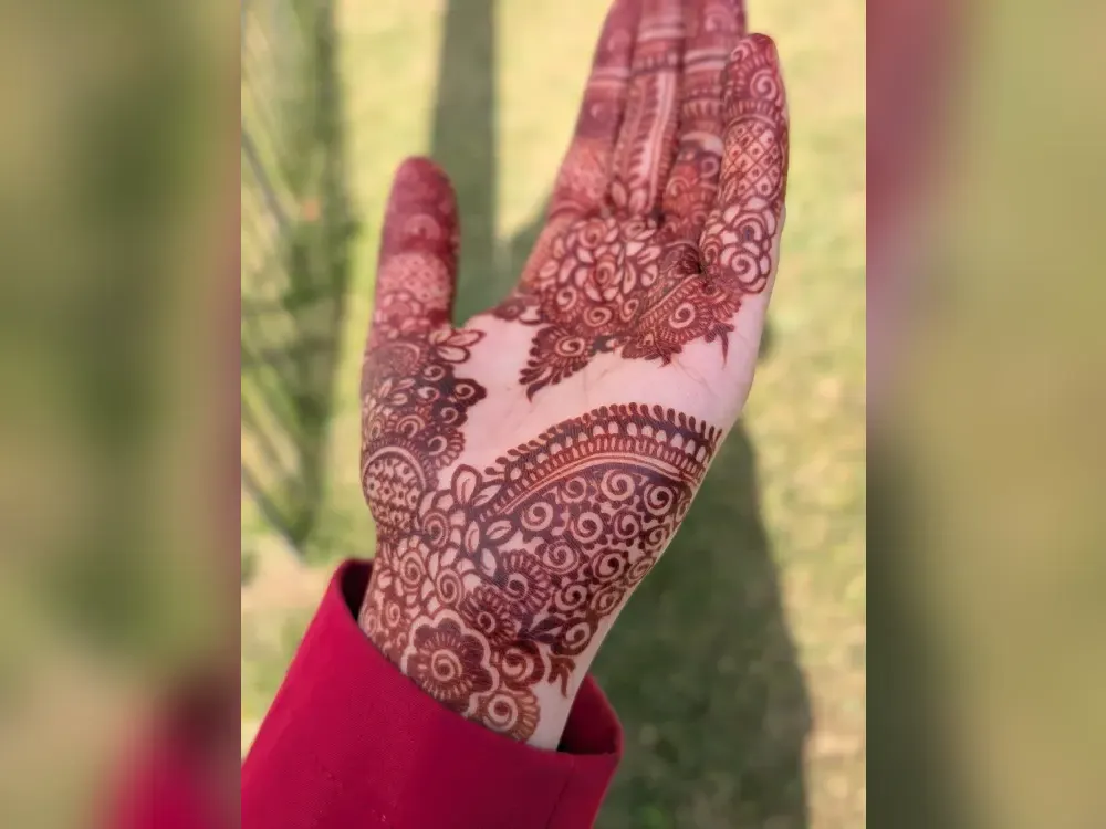 A palm holding a deep red henna stain, the darkest colour skin takes
