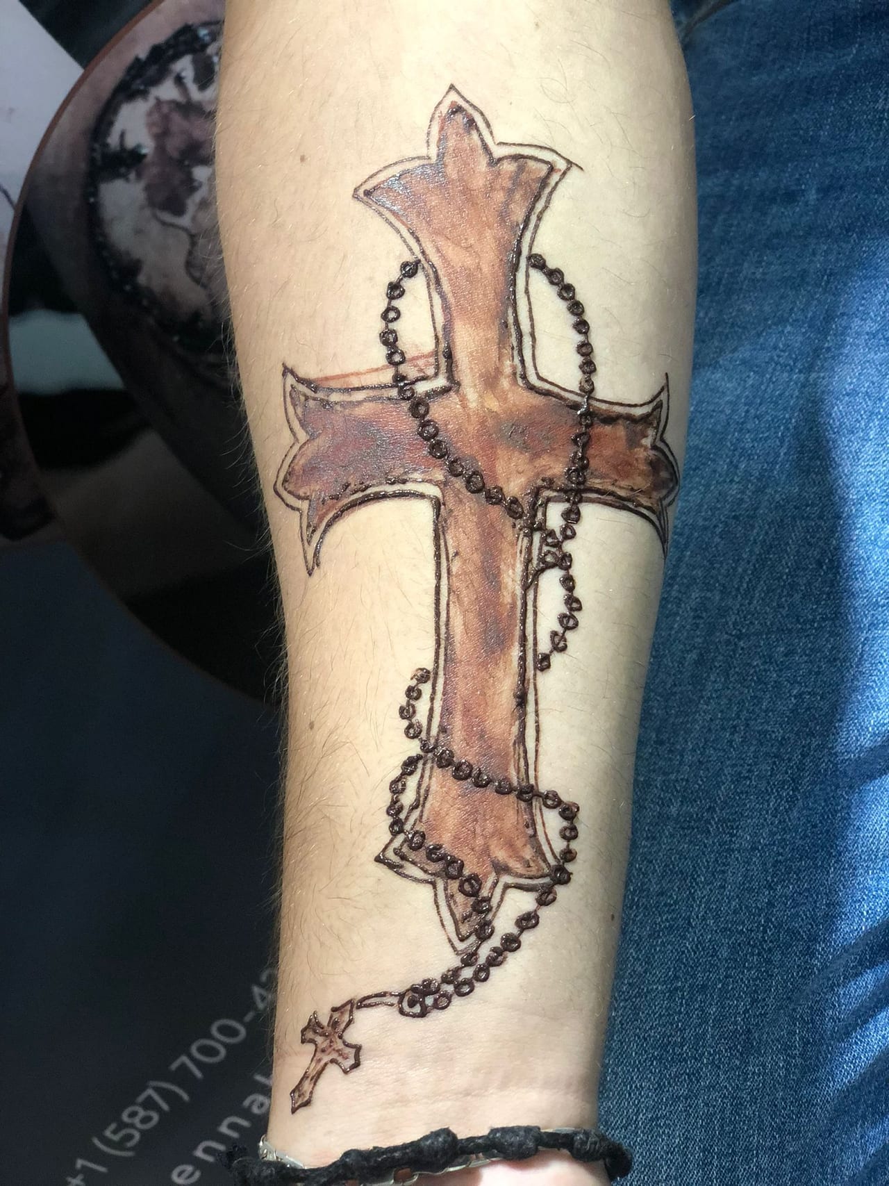 Cross and rosary henna tattoo on a forearm with soft shading, freehand, Calgary