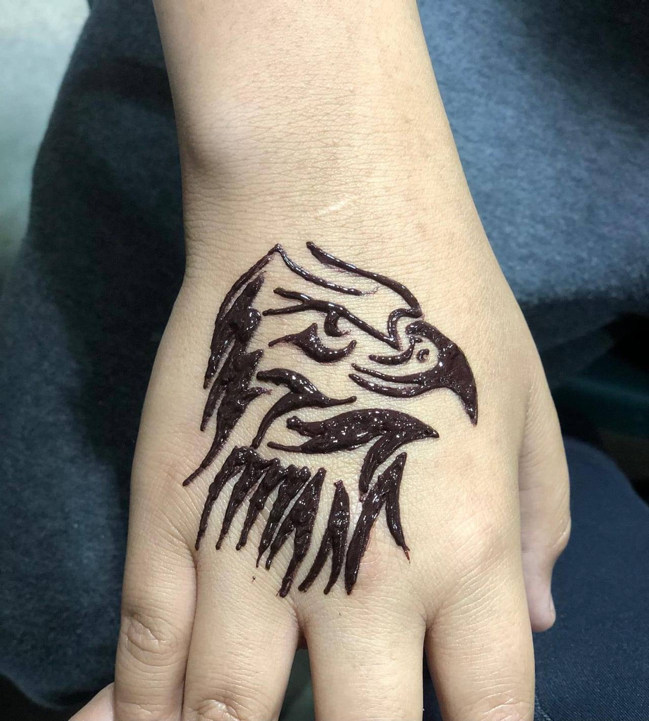 Bold eagle head henna tattoo on the back of the hand, Calgary